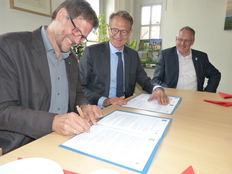 Prof. Dr. J. Prüter und IR S. Thijsen (Staatsbosbeheer) unterzeichnen die Kooperationsvereinbarung im Beisein von J. Meyer, dem Bürgermeister der Samtgemeinde Elbtalaue.