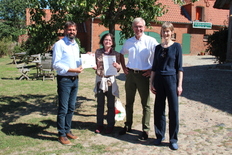 Minister Olaf Lies (l.) übergibt den Landschaftswerte-Förderbescheid an Cornelia Bretz und Julia Gerdsen vom Verein Konau 11 – Natur e.V., der von der Sparkassenstiftung Lüneburg und ihrem Geschäftsführer Carsten Junge (2.v.r.) initiiert wurde.