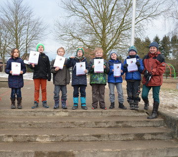 Die Kinder präsentieren stolz ihre Urkunden.