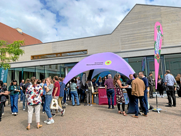 Die Teilnehmenden informieren sich am ersten Veranstaltungstag am Infostand der Nationalen Naturlandschaften über die Biosphärenreservate in Deutschland.
