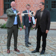 Symbolische Schlüsselübergabe an Dirk Janzen (links) durch Staatssekretär Doods (Mitte) und Johannes Prüter (rechts)